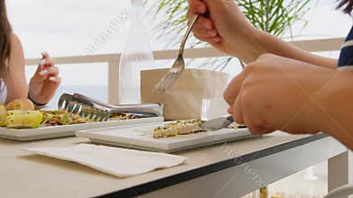 Woman Cutting Swordfish With Fork And Knife At Bach Summer Restaurant
