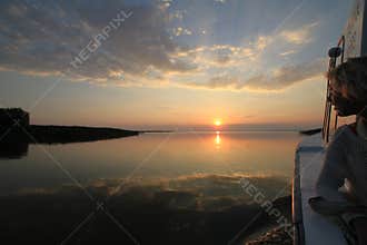 Young woman boating at sunset on the Danube Delta