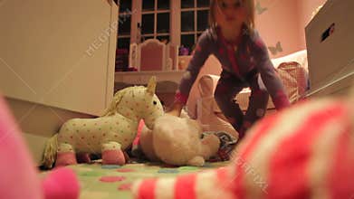 Girl Playing With Toys In Bedroom Wearing Pajamas