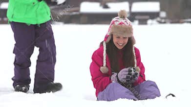 Teenage girl sits in snow