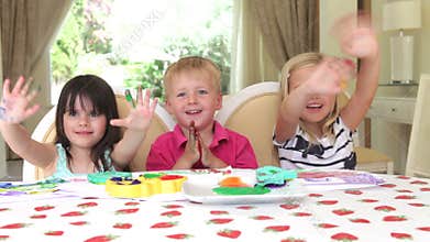 Group of three children sit