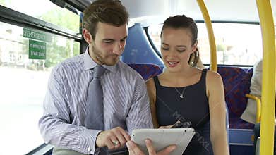 Businessman And Woman Using Digital Tablet On Bus