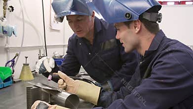 Engineer Teaching Apprentice To Use TIG Welding Machine