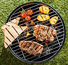 Two lamb chops cooking on a BBQ