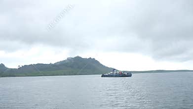 Serene Ocean Scene with Cargo Ship and Misty Mountain