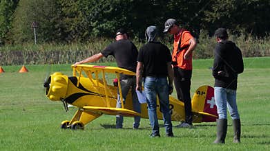 Pilots and crew preparing a Bucker Bu 133 Jungmeister RC model for flight