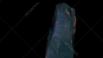 Macro shot of asymmetrical crystal with luminous natural hues slowly spinning