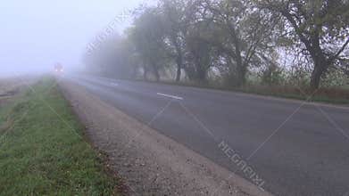 Autumn asphalt road with red truck and fog
