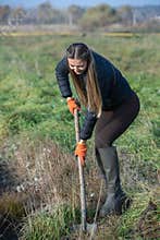 The girl plants trees on a field full of grass. afforestation campaign in Europe.