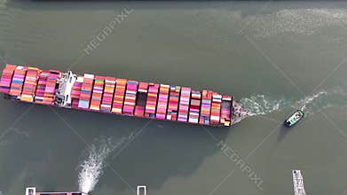 Drone shot of a large container ship entering or leaving the modern industrial container port of Rotterdam