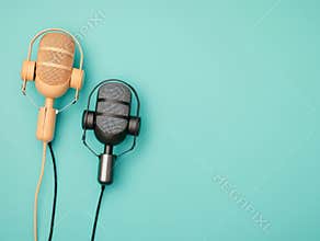 Two microphones, one old-style fabric-covered and grilled, the other modern metallic, are positioned on a dark-to-light