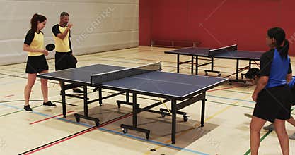 Playing table tennis, two teams competing in indoor sports hall