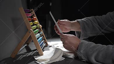 A person is using a colorful abacus to count