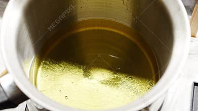 A flavoring agent is added to a container with melted wax for candles.