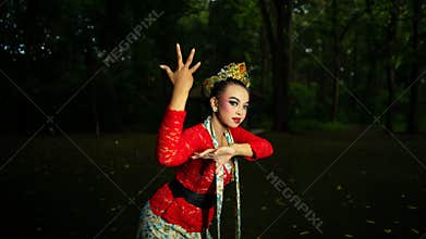 a Balinese dancer wearing a red costume which becomes a visual attraction for the audience with the beauty of the dance performed