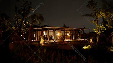 Cozy illuminated cabin at night surrounded by trees, offering a tranquil and inviting atmosphere