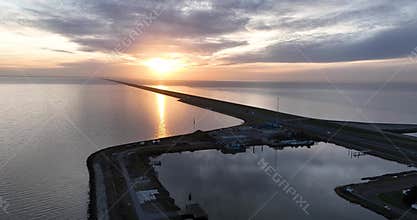 The small haven in the middle of the dutch iconic Afsluitdijk, Breezanddijk, The Netherlands. Open water at sunset
