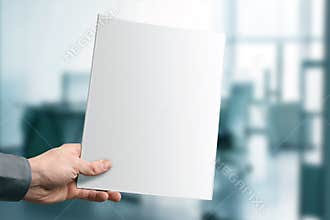 Hand holding blank magazine with copy space