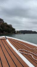 View from wooden boat approaching the shore under cloudy sky