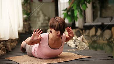 Young woman sit in Yoga breathing pose near Spa Center Pool