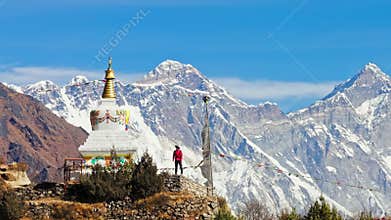 Towering Mount Everest overlooking buddhist stupa, mountaineer standing in silent reverence amid sweeping Himalayan