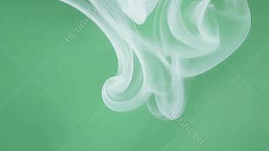 Light airy spirals of smoke gently floating embodying a serene ambiance. Green screen chromakey.