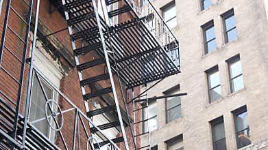 New York City building architecture, Manhattan. Residential house exterior. Red brick, fire escape.