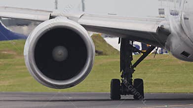 Airplane engine and landing gear taxiing on runway