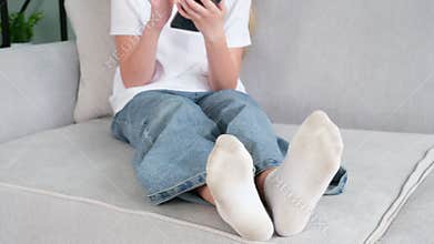 The child has dirty socks. The girl uses a mobile phone