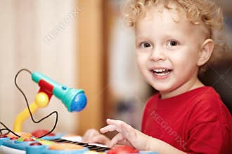 Adorable little boy playing with a toy microphone