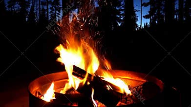 Roaring campfire flames logs burning brightly night outdoor camping warmth dark stock footage Generative AI