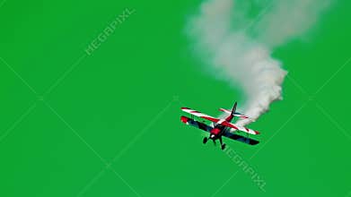 Biplane performing aerobatics on green screen background