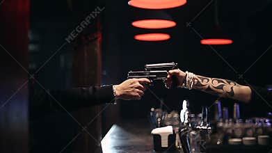 SLOW MOTION: Two male hands with guns take aim at each other
