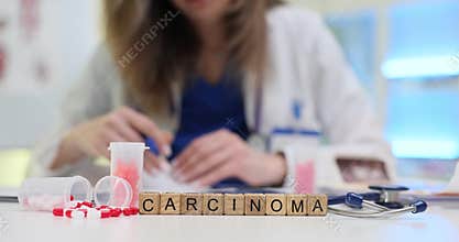 Carcinoma on blocks near pills and stethoscope on doctor desk