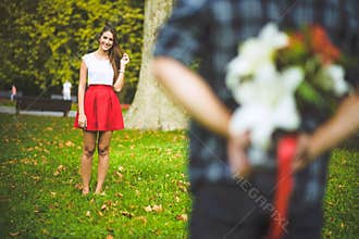 Man ready to give flowers to girlfriend