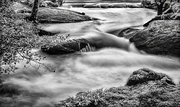 Flowing water in the Pyrenees mountains during a cloudy day