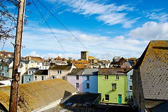 Colorful Seaside Town Architecture with Pastel Houses and Historic Church Tower Under Wispy Blue Sky