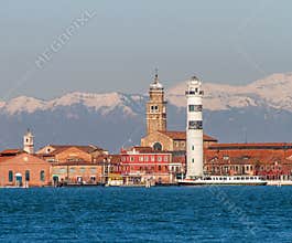 Panoramic View of Murano Island Featuring its Iconic Lighthouse and San Donato Church Against Distant Snow-Capped Mountains