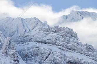 Snow covers the Pyrenees mountains while clouds drift over the peaks in winter