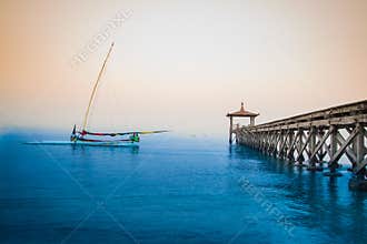Indonesian traditional boat and dock in white sand beach (Pasir putih)