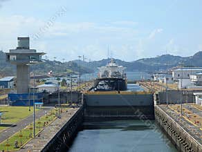 Panama Canal, Panama 2026.03.26. Cargo ship navigating Panama Canal Locks beside control tower