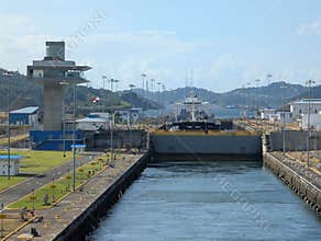 Panama Canal, Panama 2026.03.26. Cargo ship navigating Panama Canal Locks beside control tower