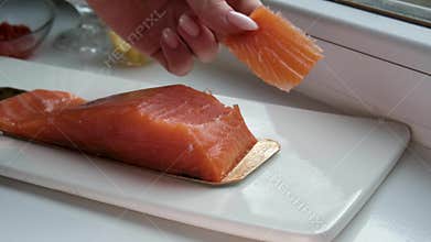 Slices of Scottish Smoked Salmon Carefully Placed on Sourdough Bread by Female Hands for Healthy Morning Breakfast