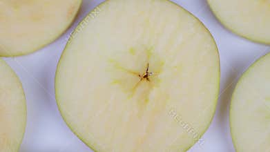 Apple cross section. Studio shot of crisp sliced green apple with dew drops. Minimalist flat lay image showcasing green apple