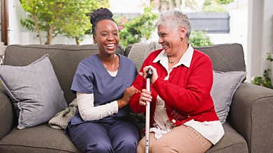 Smiling Black Carer and Senior Woman Share a Joyful Moment During a Home Visit or In a Retirement Home