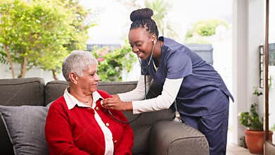 Professional Black Carer Performs Home Visit, Checking Senior Woman's Health