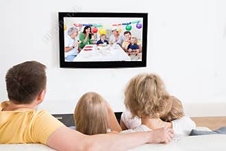 Young family watching tv together
