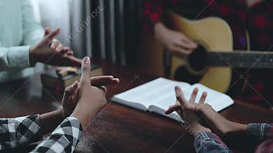 Christian worship group singing and praying together with acoustic guitar. Praise and worship, faith, fellowship, spiritual