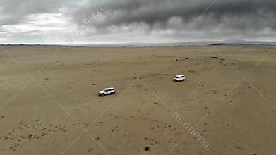 Offroad vehicles cross Gobi Desert dunes in Mongolia through remote sand country, desert convoy, sand dunes, dune crossing