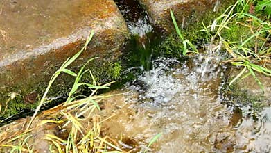 Hands washing in fresh crystal clear water from stony rural fountain. Natural drinking water from mountain.